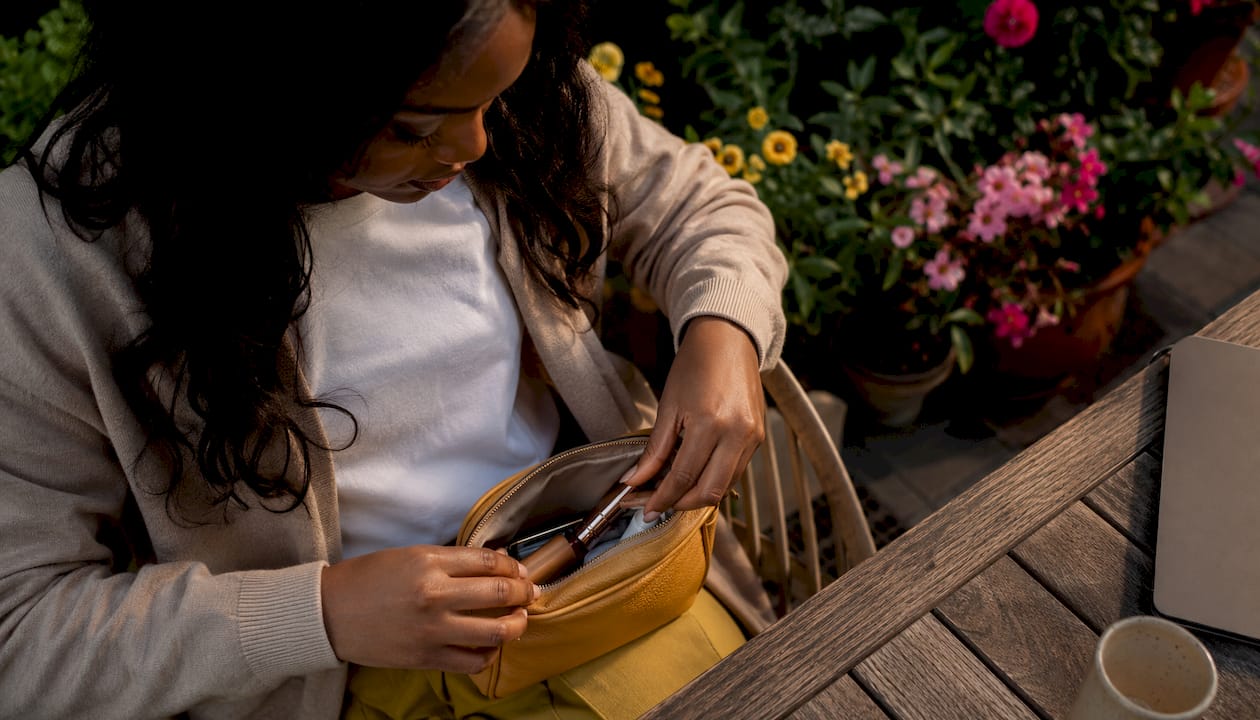 Woman organizing personal care pouch at café