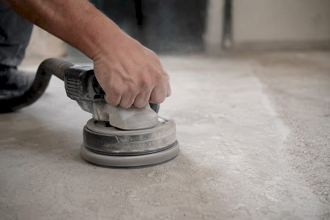 Hand operating diamond floor grinder on concrete