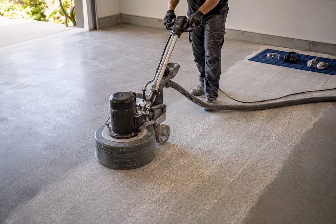 Professional grinding a garage concrete floor