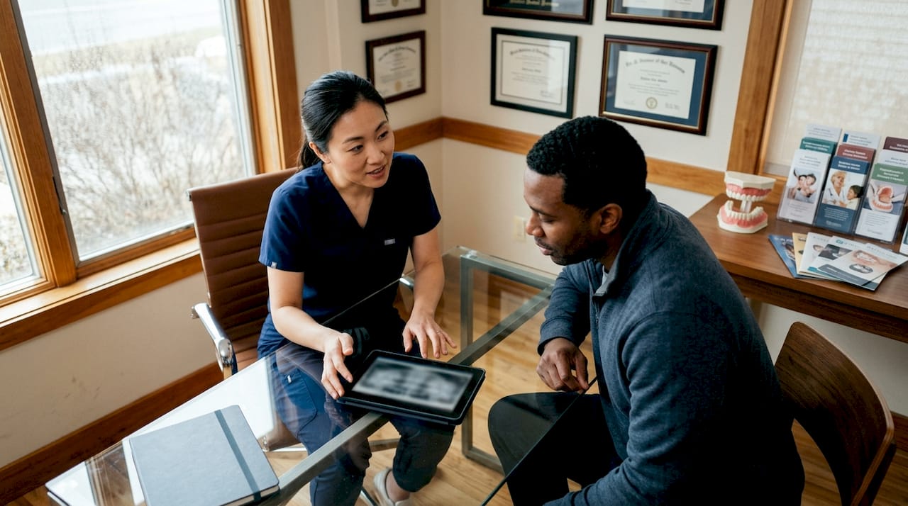 Dentist and patient discussing dental implant coverage