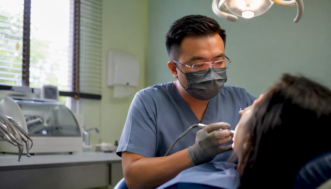 Dentist performing dental implant procedure in Mexico clinic