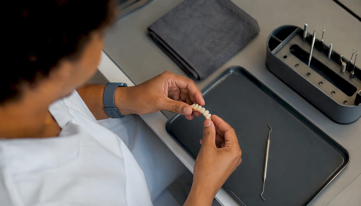 Dental technician handling temporary prosthesis