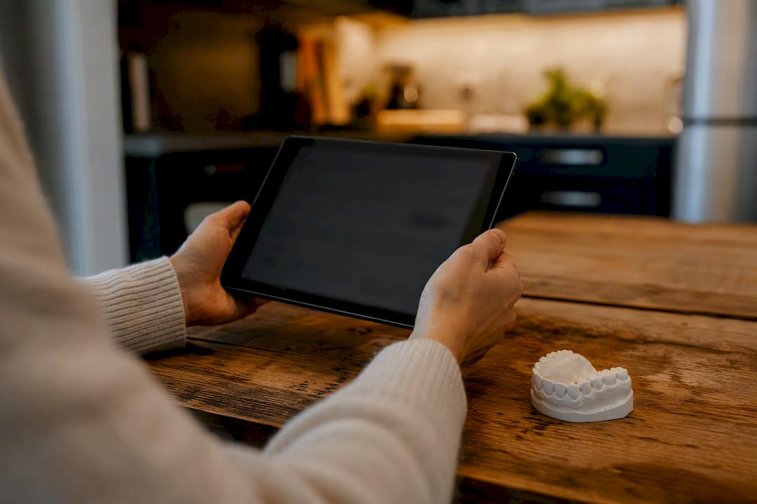 Hands with dental veneer model and tablet