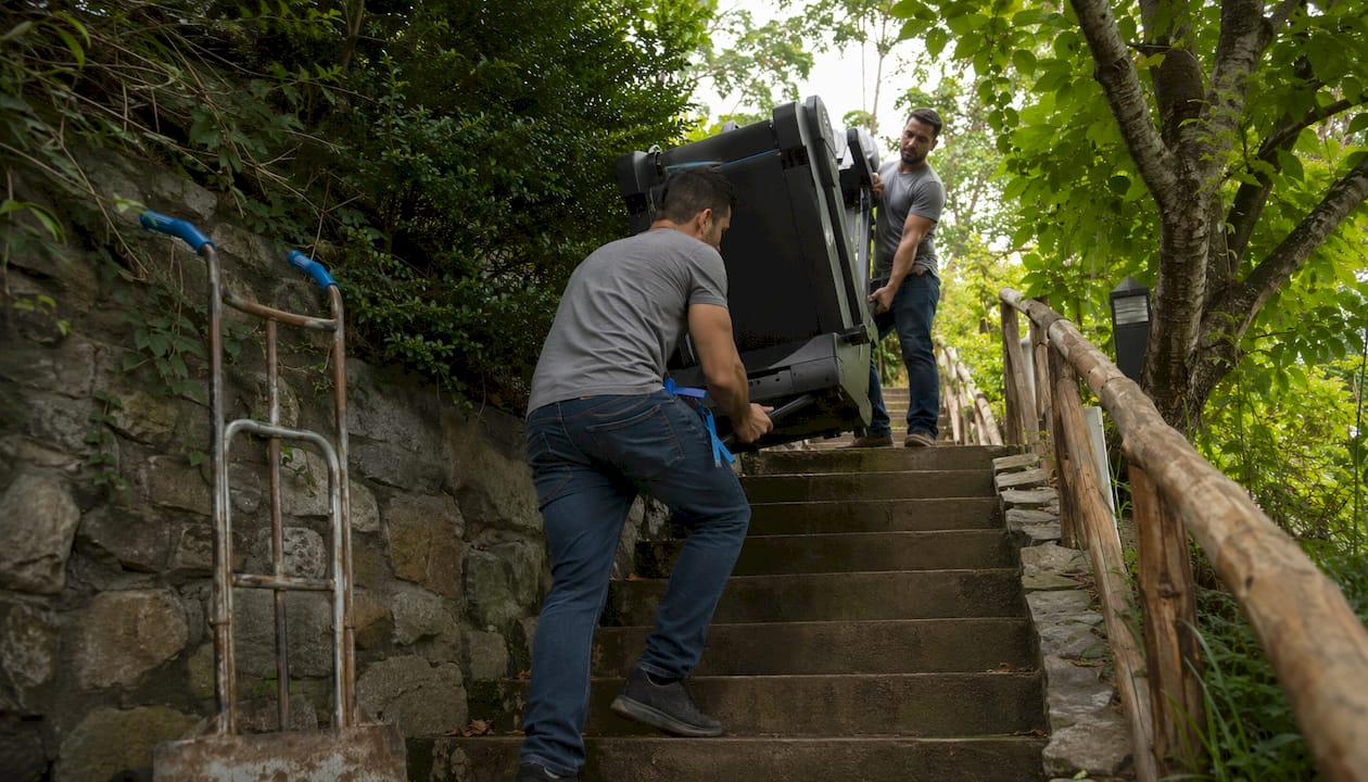 Two movers carrying treadmill upstairs
