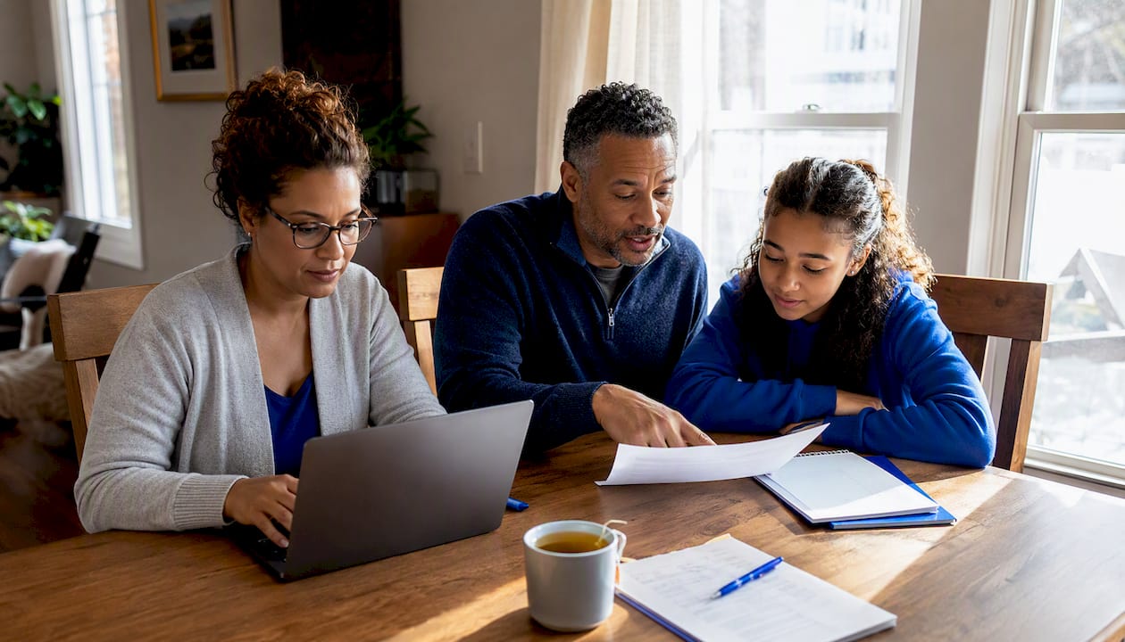 Family reviewing moving insurance paperwork at table