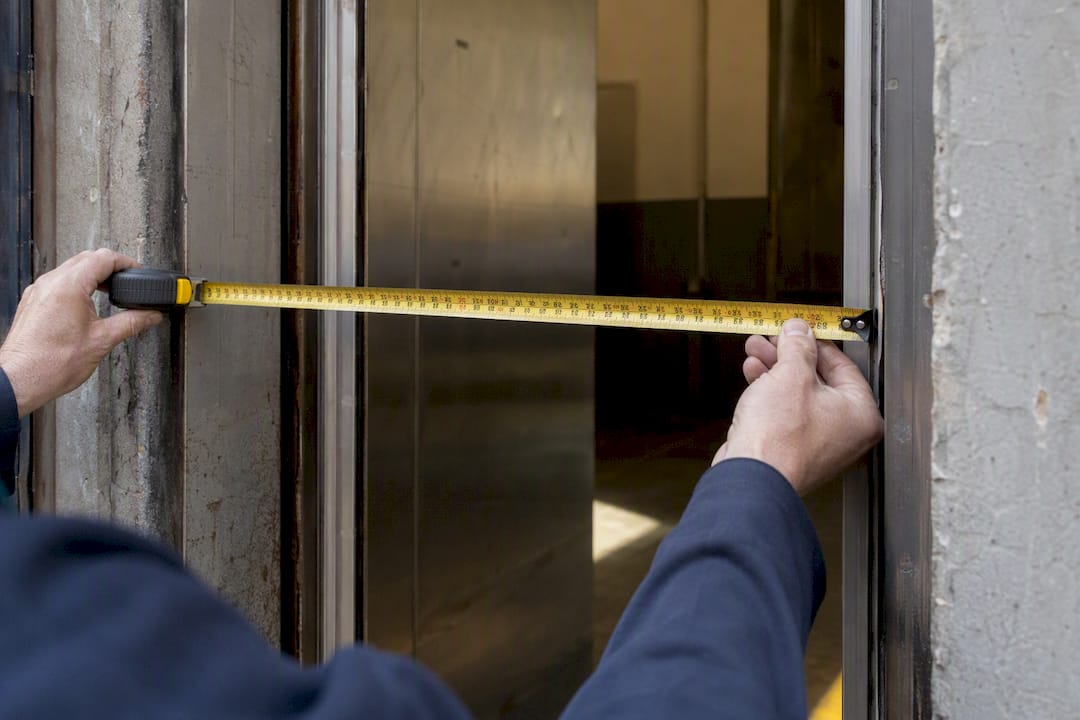 Hands measuring freight elevator door width