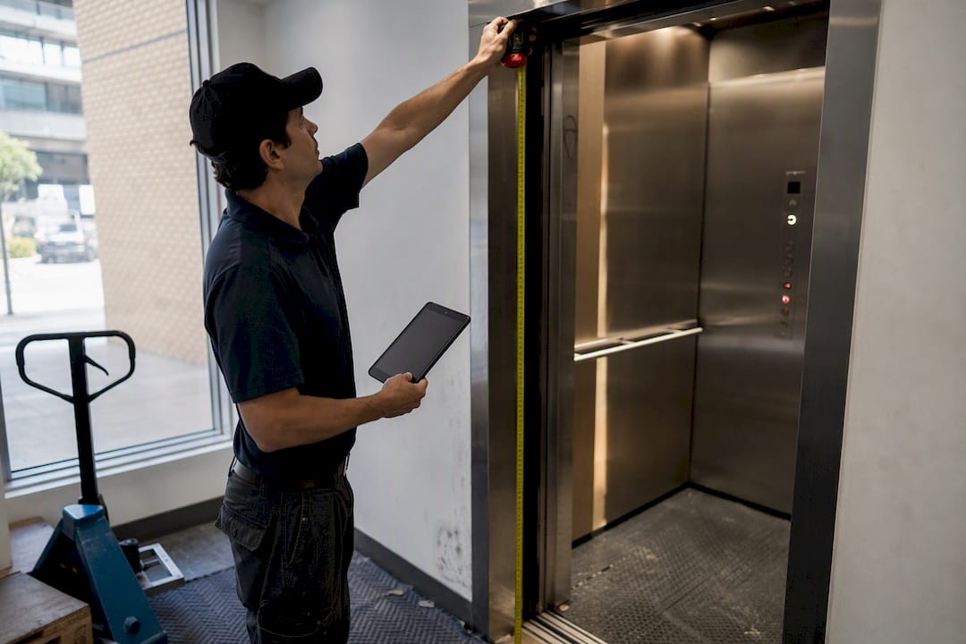 Hands measuring elevator door width