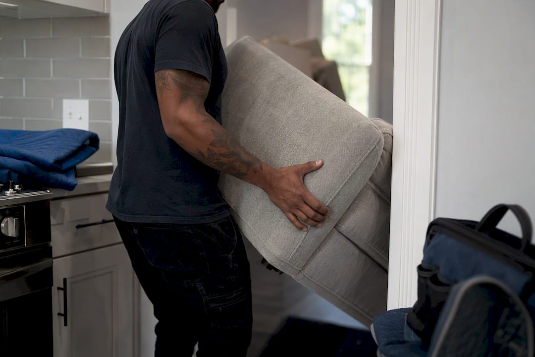 Mover tipping sofa through narrow doorway