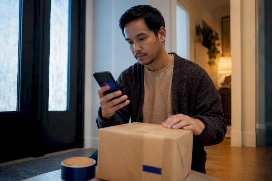 Seller verifying payment before shipping parcel