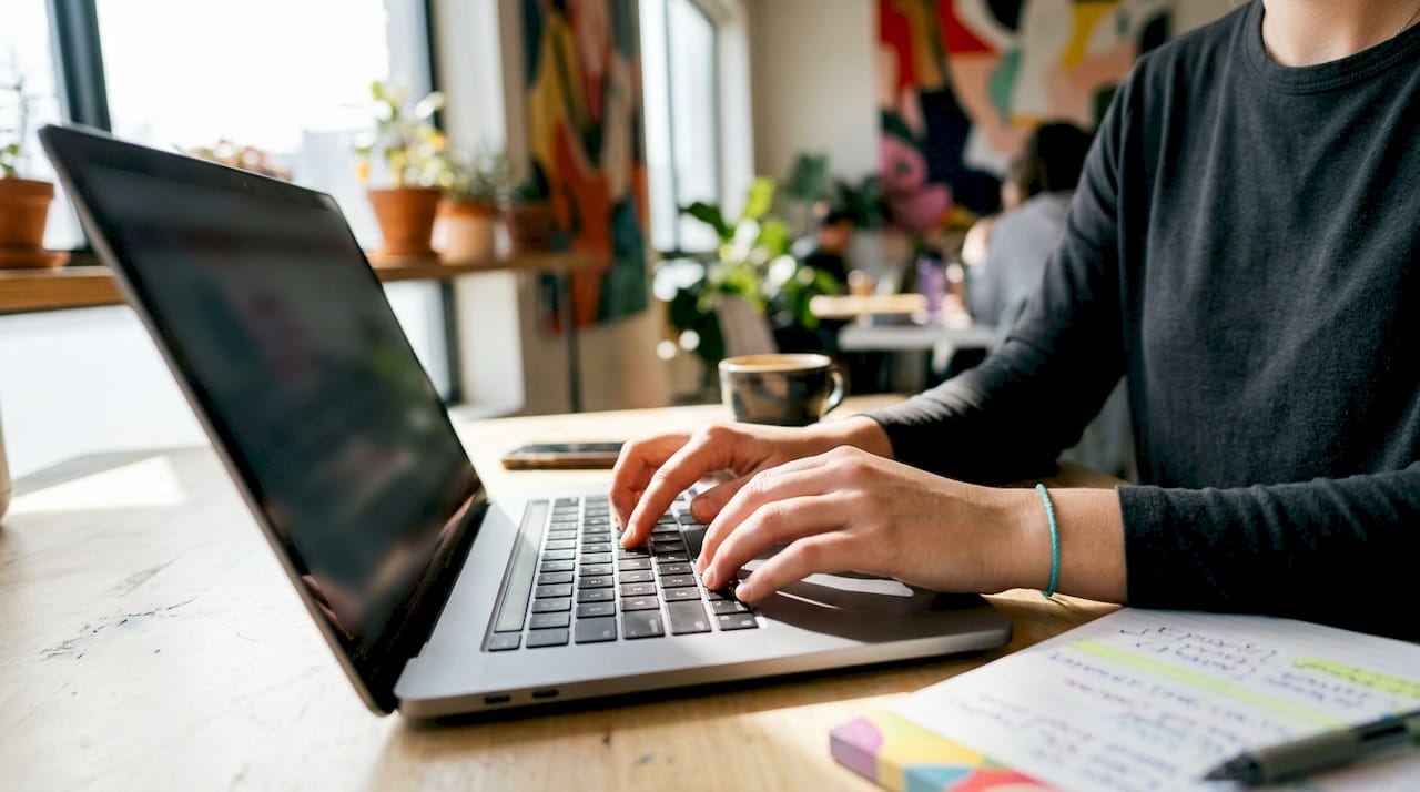 Hands typing on laptop at modern office desk