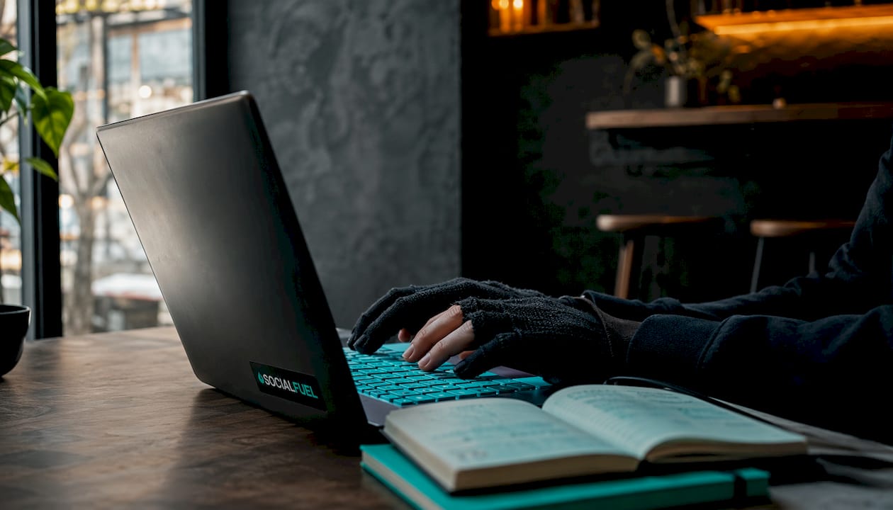 Hands typing by keyboard with mint-green ambient light