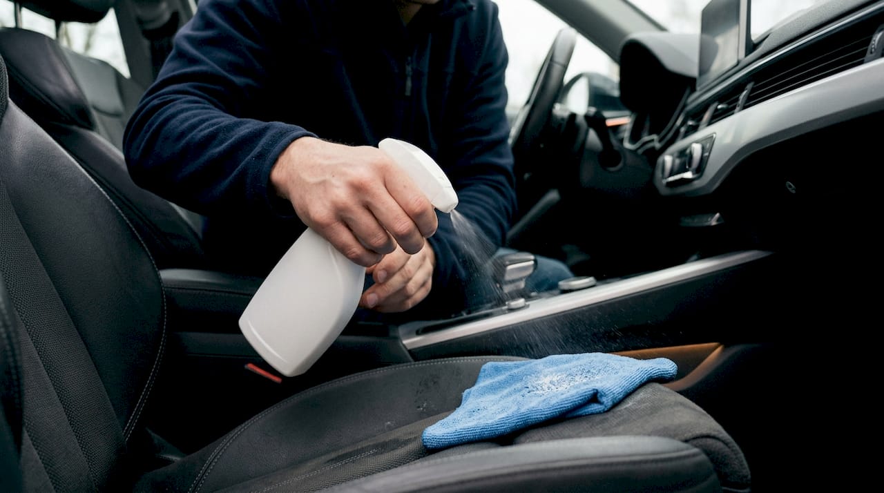 Spray wat interieurreiniger op een doek voordat je gaat schoonmaken.