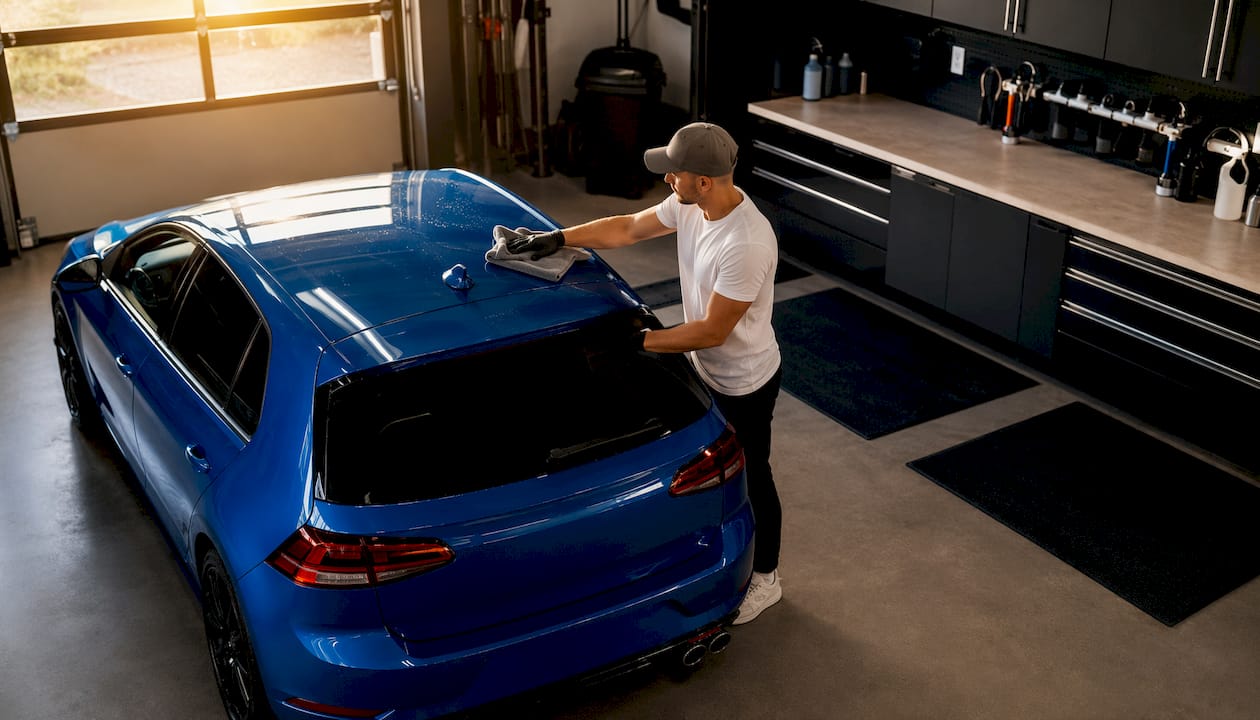 De detailer droogt de auto zorgvuldig af, uit de buurt van direct zonlicht.
