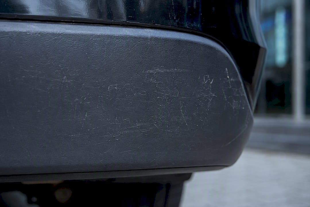 Geschonden grijze plastic autorand van bumper, close-up
