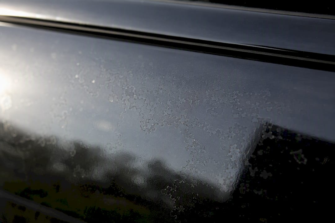 Close-up van ruwe watervlekken op autolak