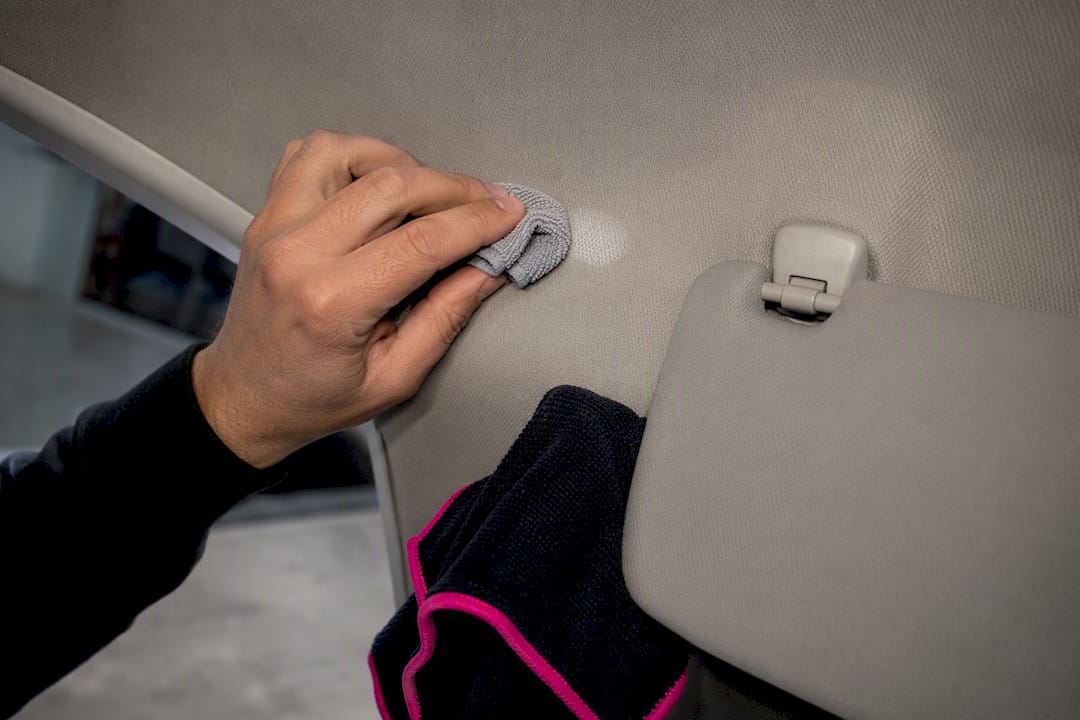 Test de reiniger eerst op een onopvallende plek bij de zonneklep