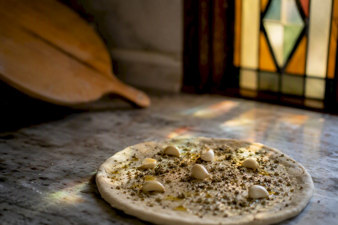Garlic and oregano on pizza dough base
