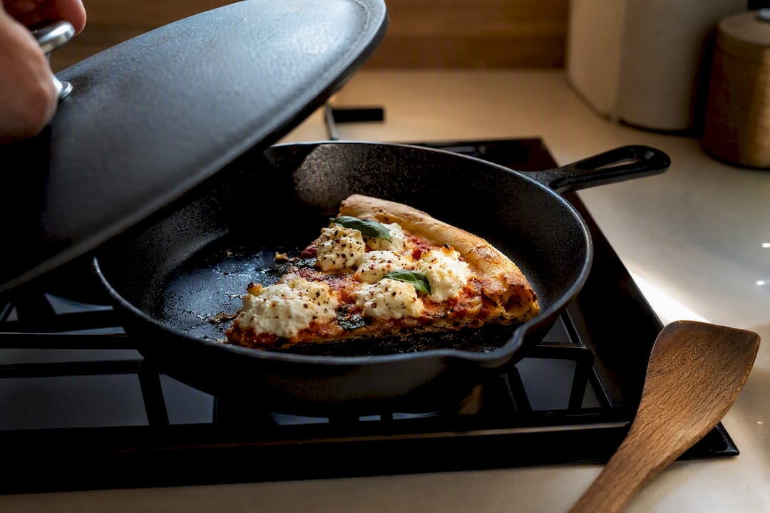 Ricotta pizza slice reheating in skillet