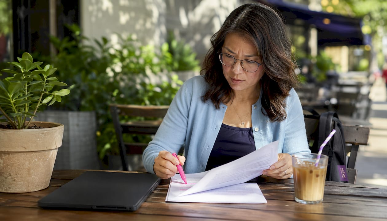 Asian woman reviewing workplace report in café