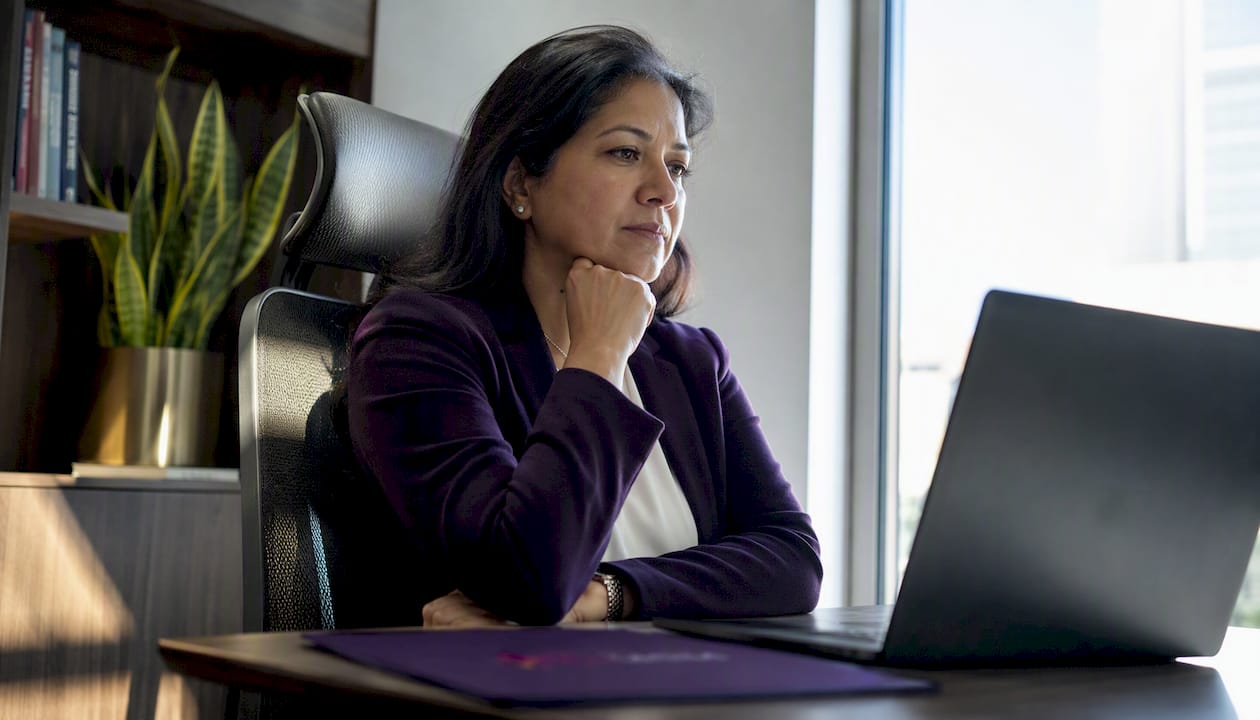 Woman pausing thoughtfully during leadership call