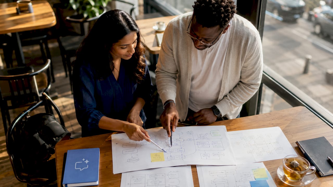 Two professionals collaborating on process redesign documents