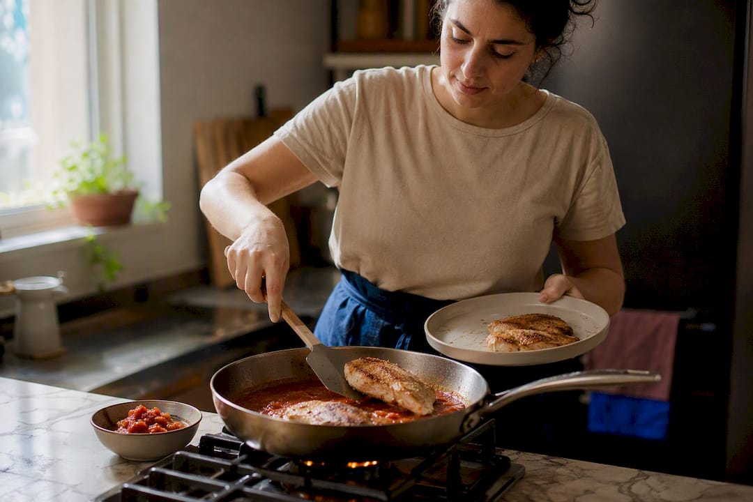 Chicken cutlets finishing in tomato sauce