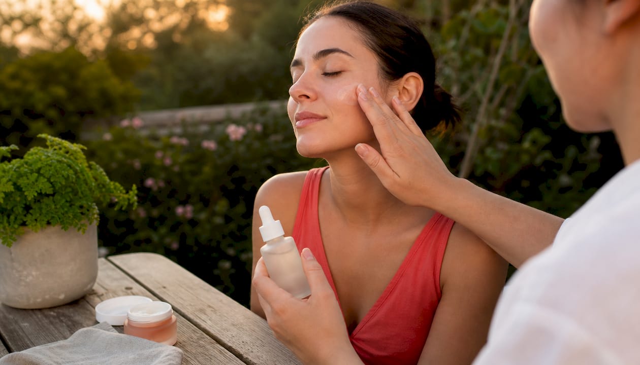 Hands applying retinol serum on skin
