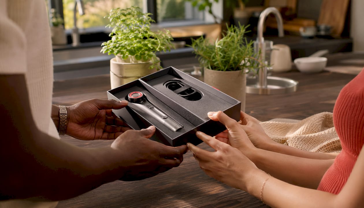 Hands examining FDA cleared RF EMS LED device packaging