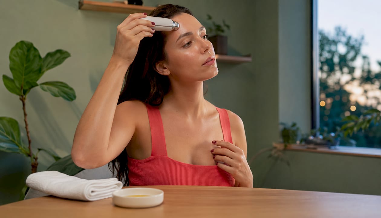 Hands using lymphatic drainage device on face