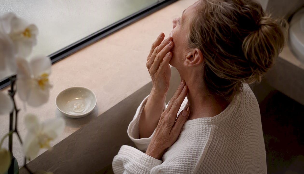 Hands massaging hydrating serum into skin
