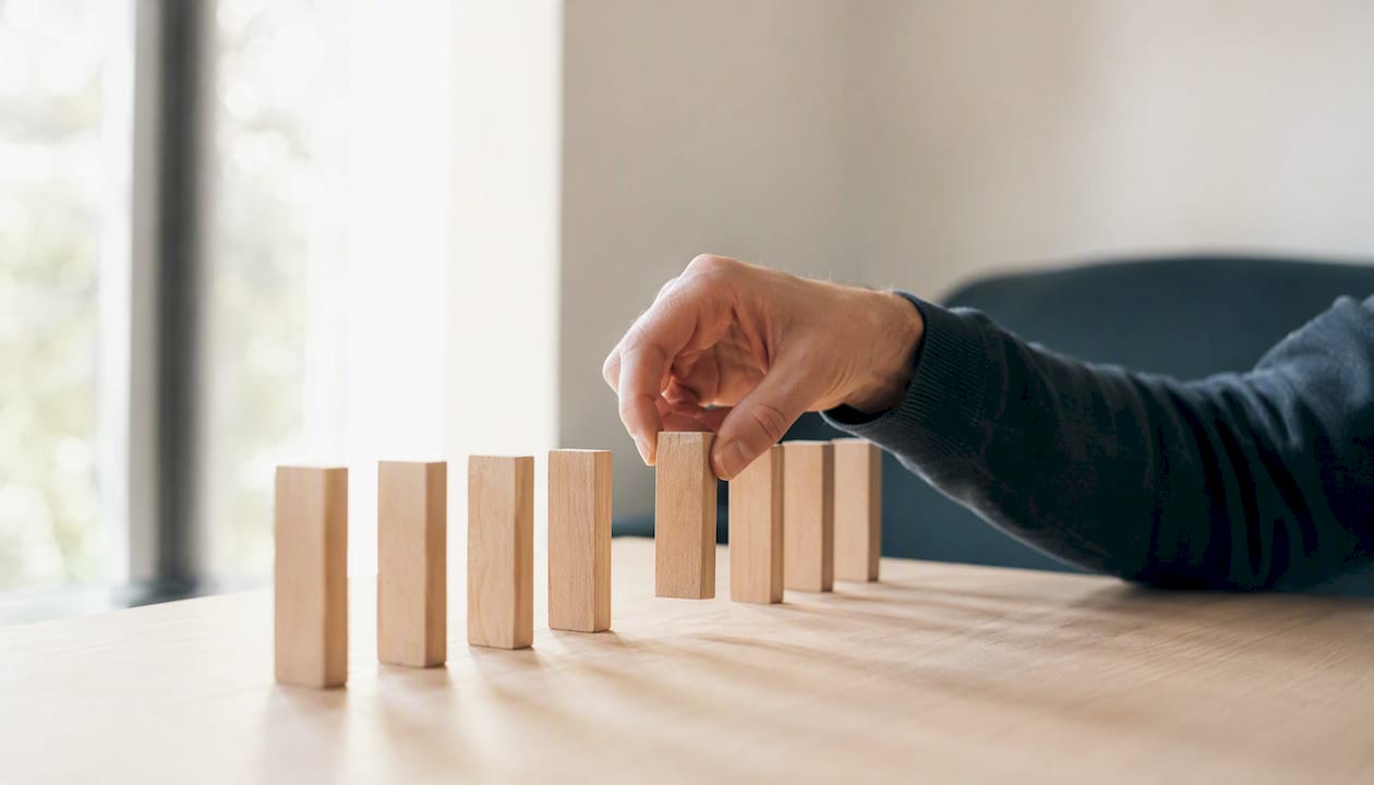 1786534975720 Hand arranging blocks to prioritize tasks Eventos sin código en GA4: activa y valida sin programar LG DATAONE 1 Priorización de eventos de GA4 según su importancia para el negocio