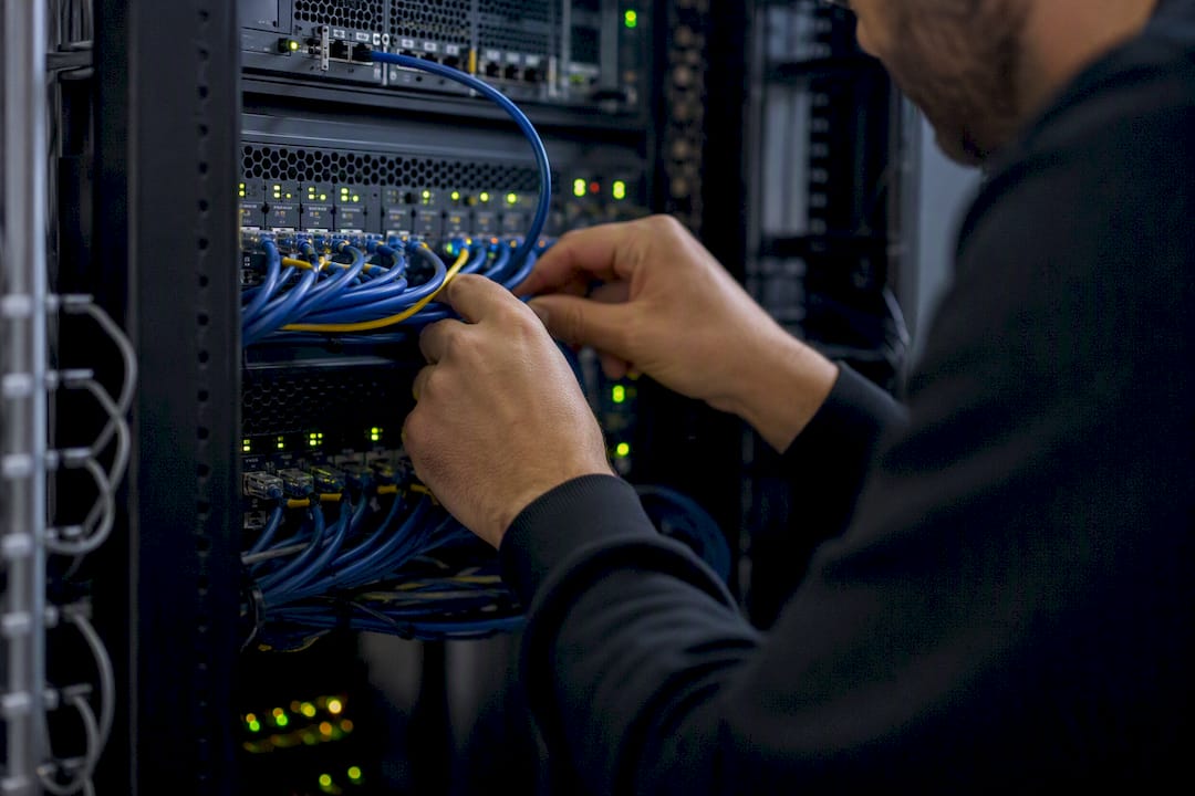 Unas manos conectando y organizando cables en el rack de un servidor