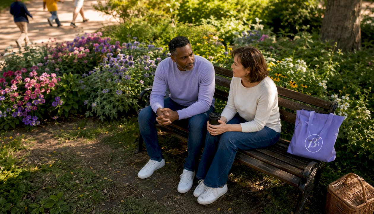 Couple discussing impulsive reactions outdoors at café table