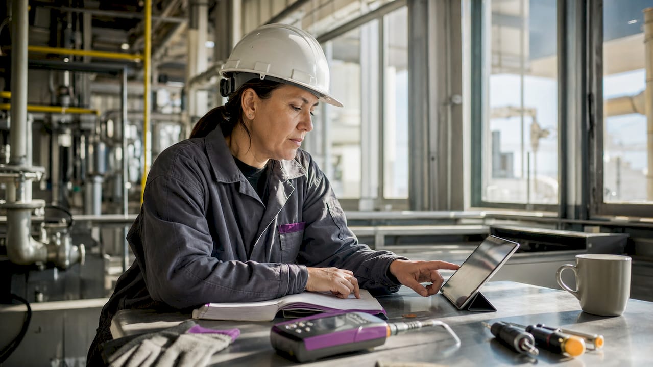 Overhead view of engineer using tools and tablet