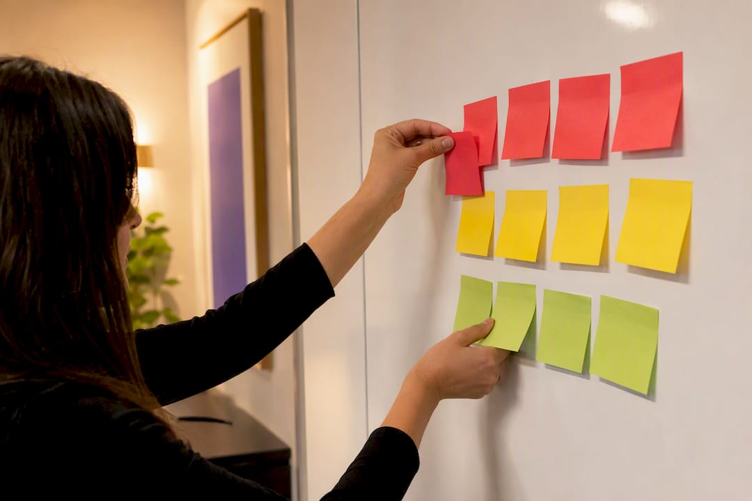 Hands organizing colored sticky notes by priority