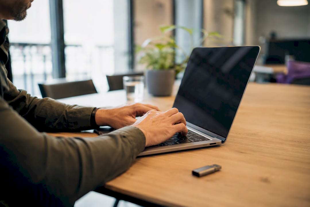 Hands correcting CSV errors on laptop keyboard