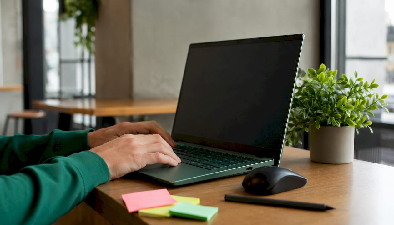 Hands typing at keyboard in modern office