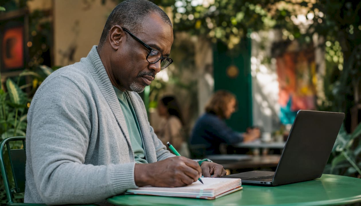 Man practicing Excel with notebook at café