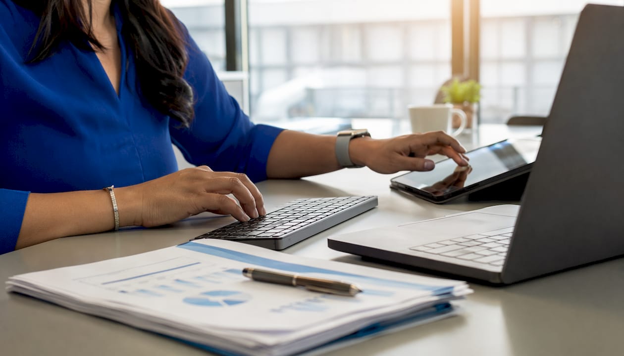 Hands managing CRM tools and analytics on desk