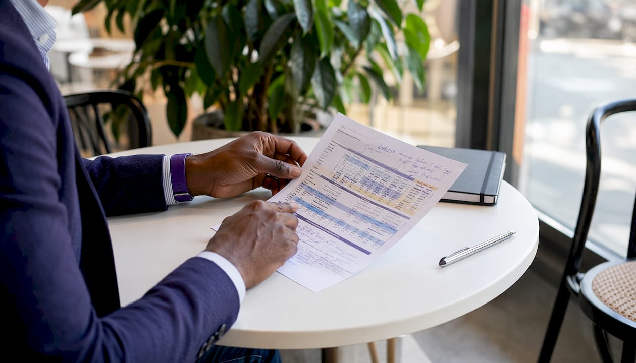 Close-up of salary chart and hands