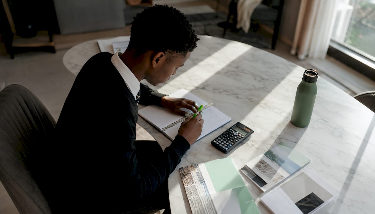 Student writing notes at study desk