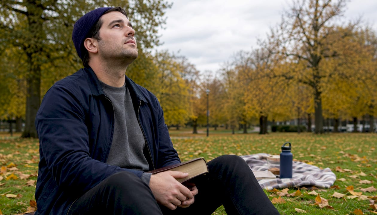 Un ragazzo si sofferma a pensare alla propria fede immerso nella natura.