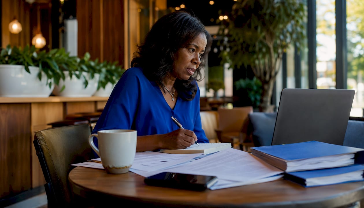 Woman taking notes on documents in office research setting