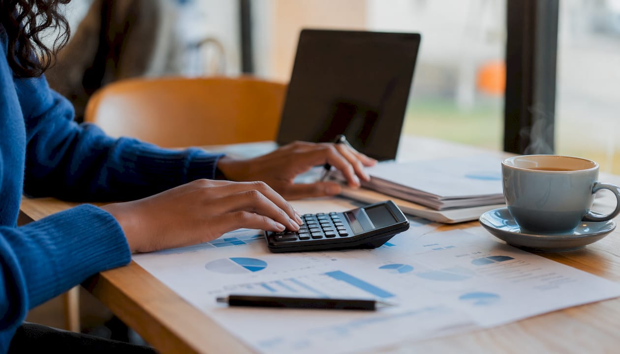 Dita che digitano su una calcolatrice finanziaria
