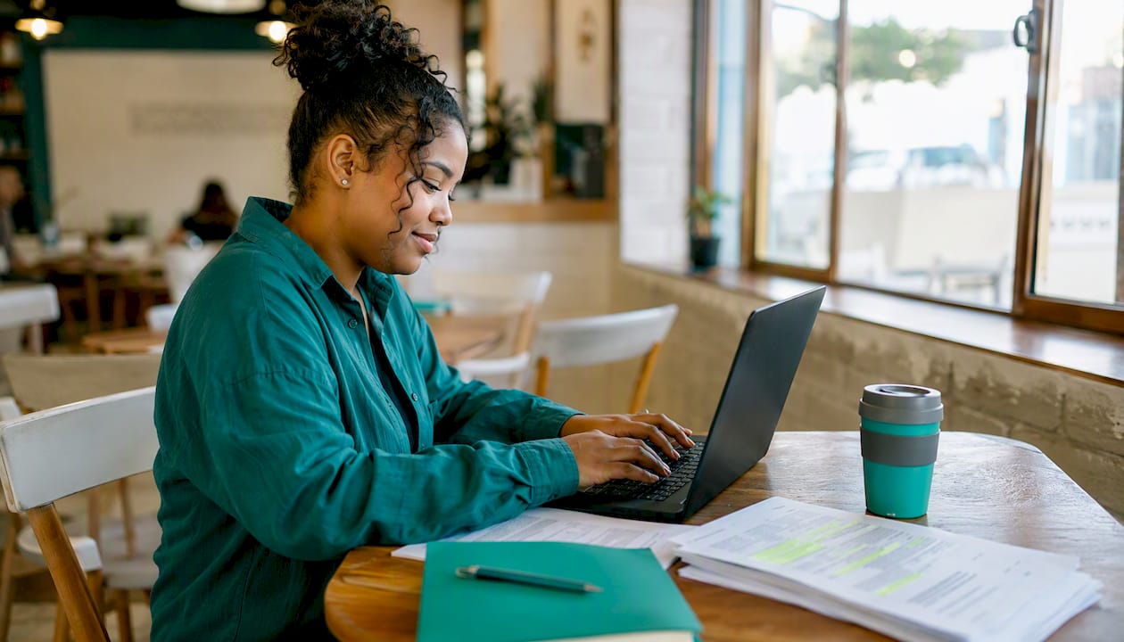 Overhead hands typing with CV and job description