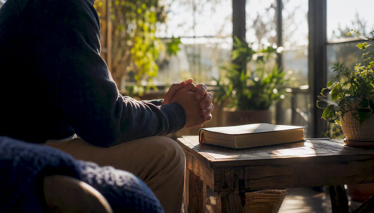 Person praying quietly at a home desk