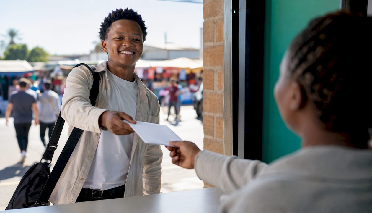 Handing over job application envelope in retail store
