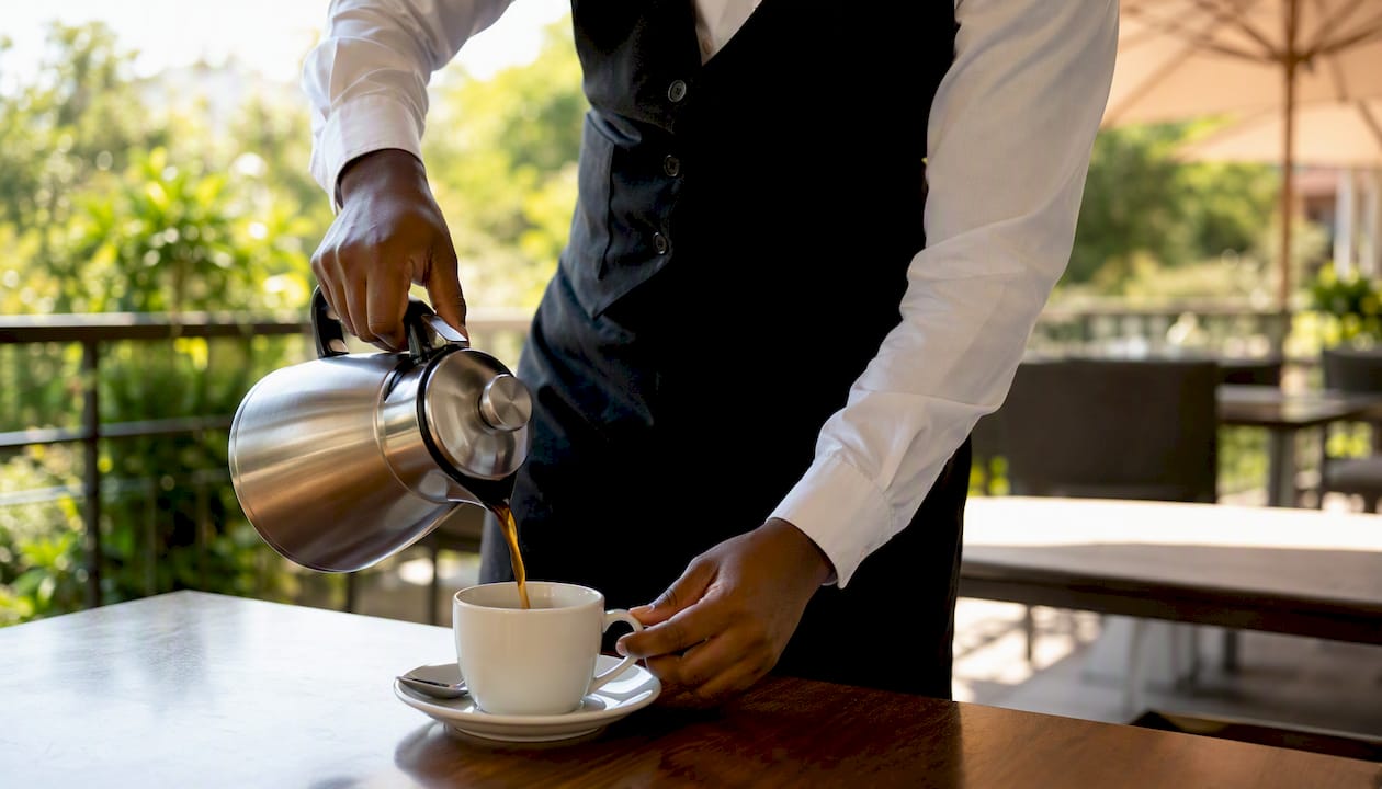 Hands pouring coffee in hospitality practical training