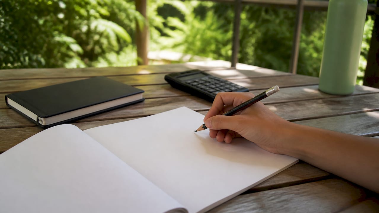 Student hand poised to write Life Sciences essay