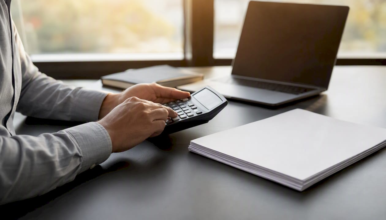 Hands using calculator for PMI monthly payment